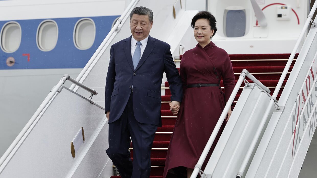 Председатель КНР Си Цзиньпин и его супруга Пэн Лиюань прибывают в аэропорт Орли к югу от Парижа, воскресенье, 5 мая 2024 года.