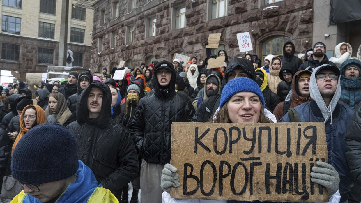 Активистка держит плакат с надписью Коррупция - враг нации во время акции протеста перед зданием городского совета Киева