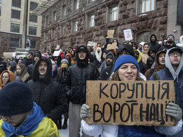 Активистка держит плакат с надписью Коррупция - враг нации во время акции протеста перед зданием городского совета Киева Активистка держит плакат с надписью Коррупция - враг нации во время акции протеста перед зданием городского совета Киева