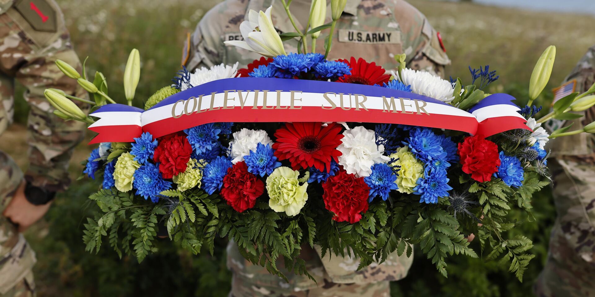 Американский солдат держит венок из цветов во время церемонии возложения венков к памятнику 1-й пехотной дивизии в рамках церемоний, посвященных 80-й годовщине Дня Д недалеко от пляжа Омаха, Нормандия - ИноСМИ, 1920, 11.06.2024
