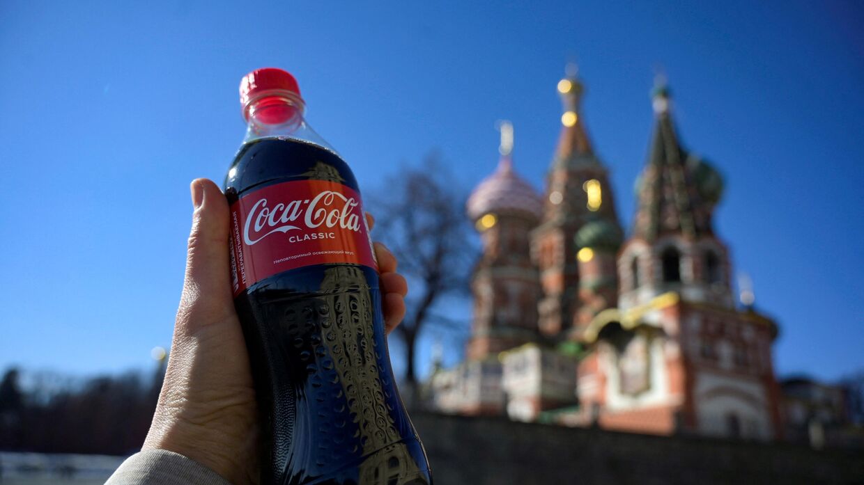 Бутылка Coca-Cola на фоне собора Василия Блаженного в центре Москвы