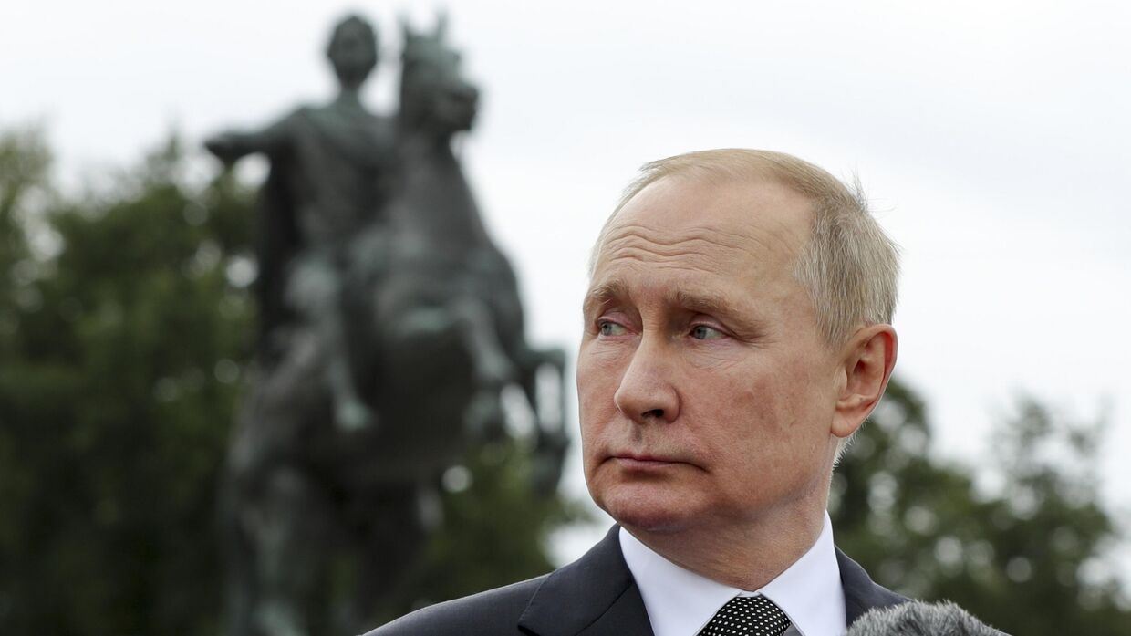 Президент России Владимир Путин на фоне конной статуей Петра Великого перед началом парада во время празднования Дня Военно-морского флота в Санкт-Петербурге 31 июля 2022 года.