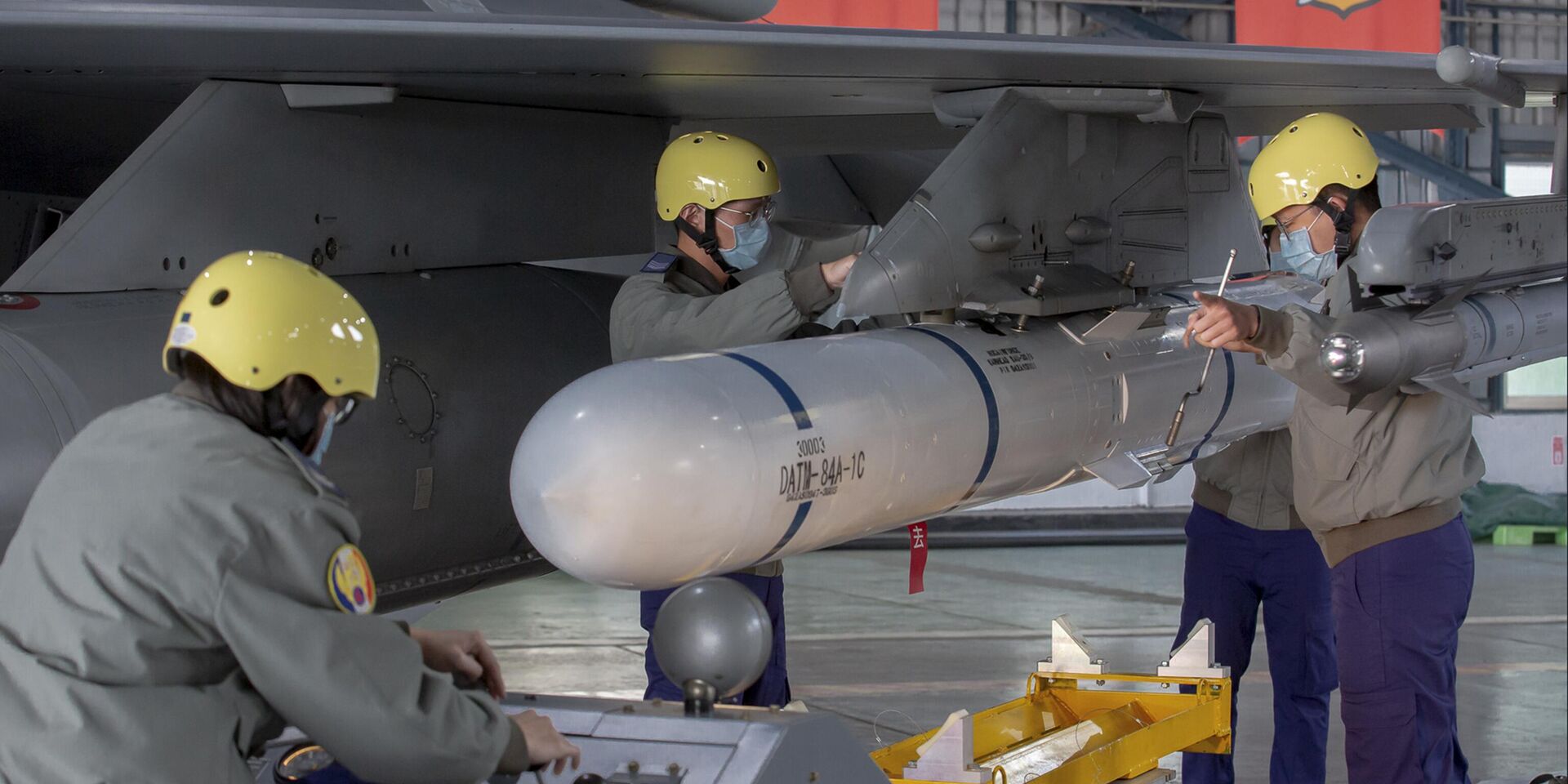 Бригада наземного обслуживания прикрепляет ракету к крылу реактивного истребителя F-16 на базе ВВС в Чиайи, Тайвань. 6 января 2023 года. - ИноСМИ, 1920, 28.06.2024