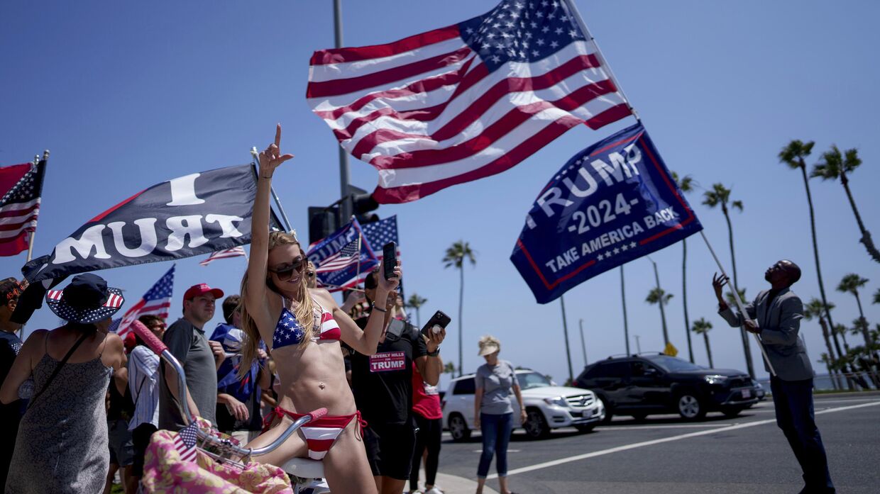 Люди митингуют в поддержку кандидата в президенты от Республиканской партии, бывшего президента Дональда Трампа, в Хантингтон-Бич, Калифорния, 14 июля 2024 года.