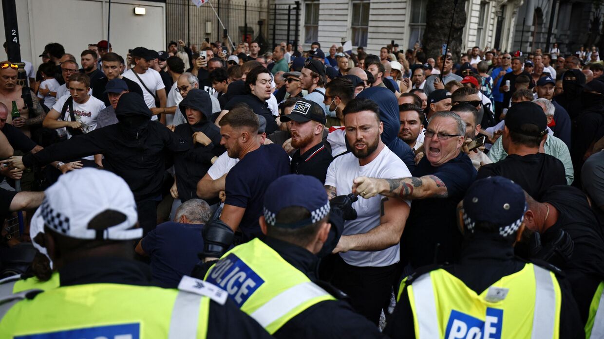 Собравшиеся у входа на Даунинг-стрит, 10 в центре Лондона, выражают протест в ходе демонстрации Хватит   31 июля 2024 года, которая стала реакцией на действия правительства на поножовщину со смертельным исходом в Саутпорте 29 июля