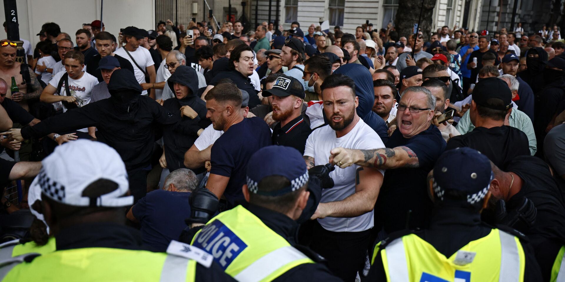 Собравшиеся у входа на Даунинг-стрит, 10 в центре Лондона, выражают протест в ходе демонстрации Хватит   31 июля 2024 года, которая стала реакцией на действия правительства на поножовщину со смертельным исходом в Саутпорте 29 июля - ИноСМИ, 1920, 05.08.2024