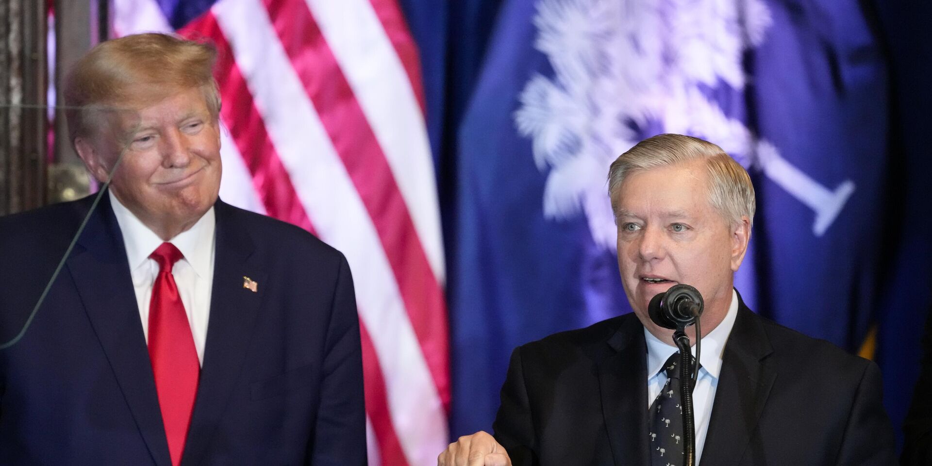 Дональд Трамп слушает выступление сенатора Линдси Грэма на своем предвыборном мероприятии в 2023 году - ИноСМИ, 1920, 07.07.2025