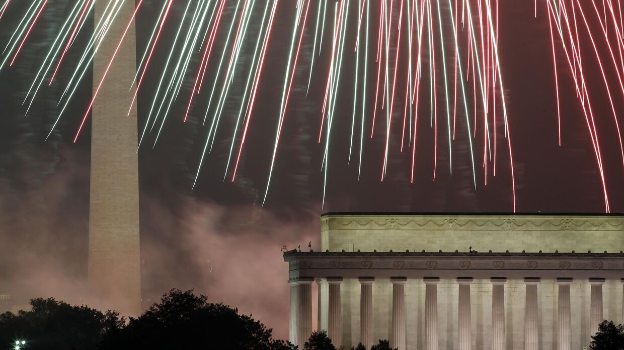 Фейерверк озаряет небо над монументом Вашингтона (слева) и мемориалом Линкольна в Вашингтоне 4 июля 2012 года