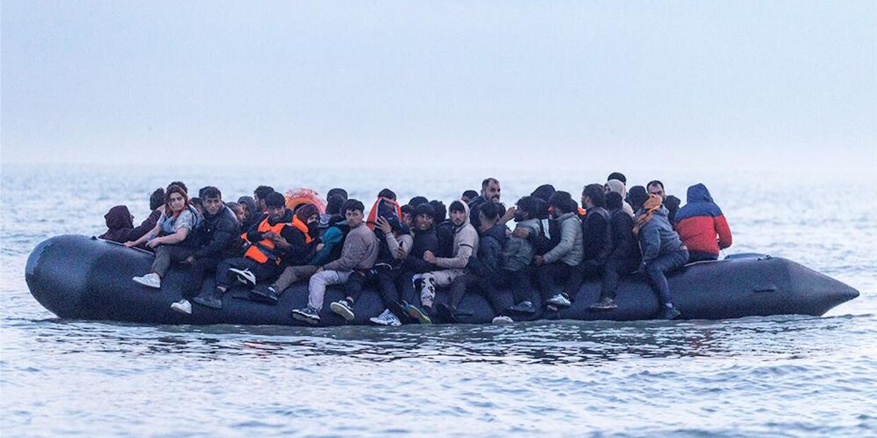 Мигранты отплывают от берега на небольшой лодке из Франции с целью пересечь пролив Ла-Манш и добраться до Великобритании