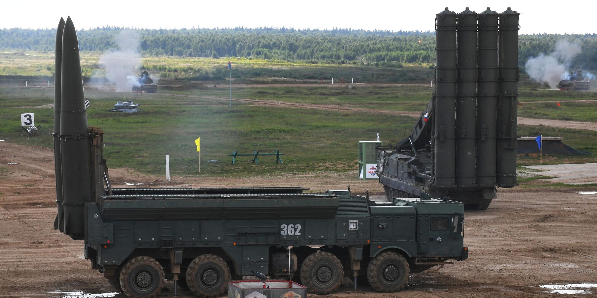 Оперативно-тактический ракетный комплекс (ОТРК) Искандер-М (слева на первом плане) и пусковая установка зенитно-ракетного комплекса C-300 (справа на дальнем плане) во время генеральной репетиции динамического показа военной техники на полигоне Алабино в августе 2021 года - ИноСМИ, 1920, 17.07.2025