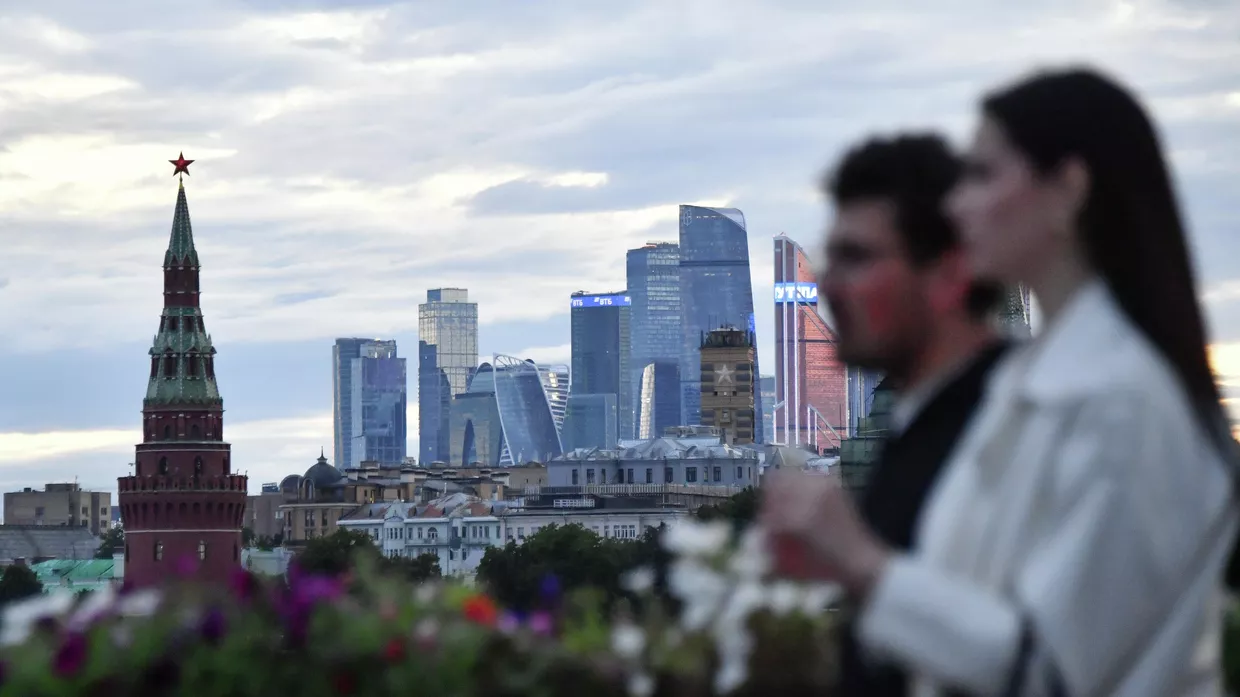 Молодой человек с девушкой идут по Большому Москворецкому мосту в Москве