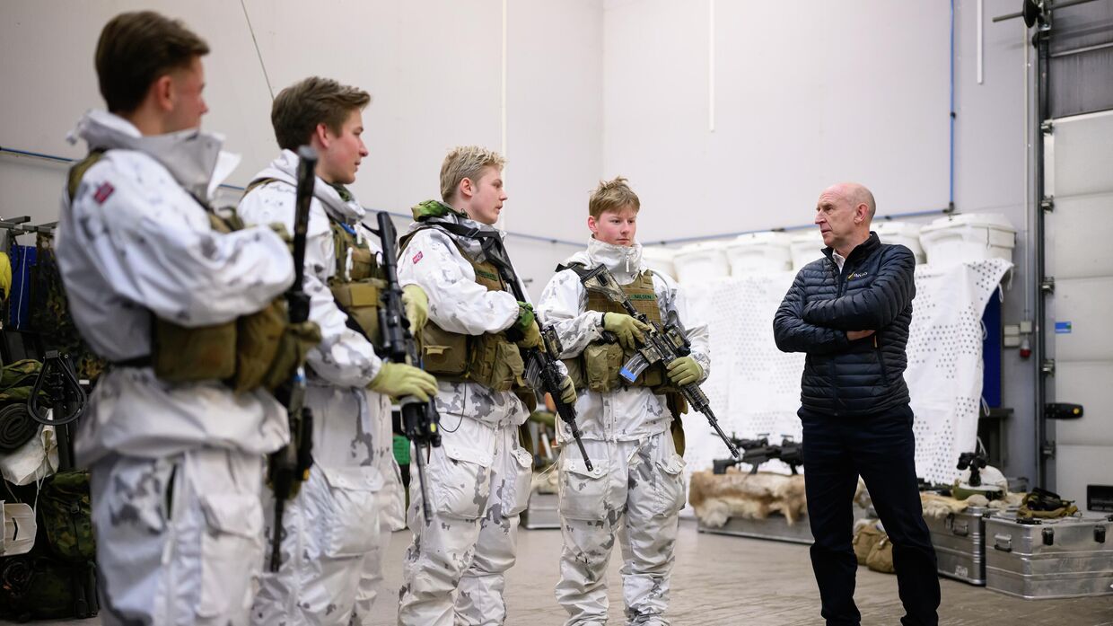 Министр обороны Великобритании Джон Хили (справа) беседует с молодыми солдатами на норвежско-российской границе 19 февраля 2025 года недалеко от Киркенеса, Норвегия.