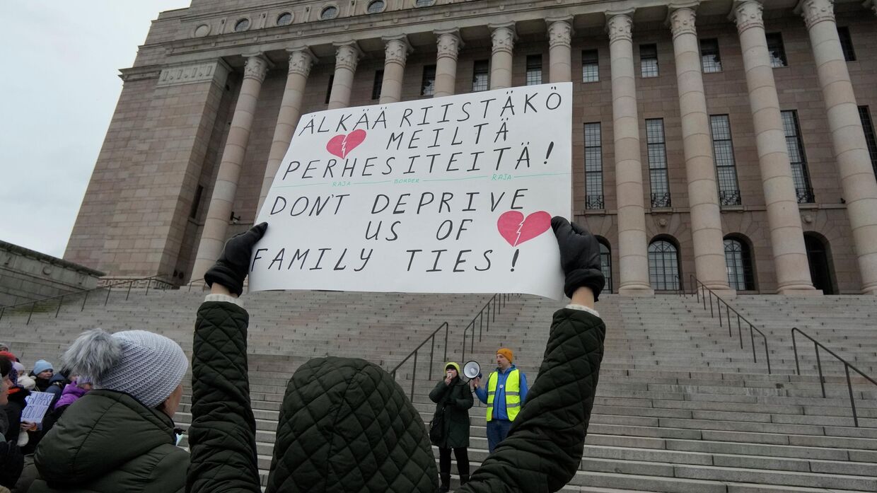 Люди, большинство из которых этнические русские, собрались перед зданием финского парламента в знак протеста против закрытия пунктов пересечения границы с Россией