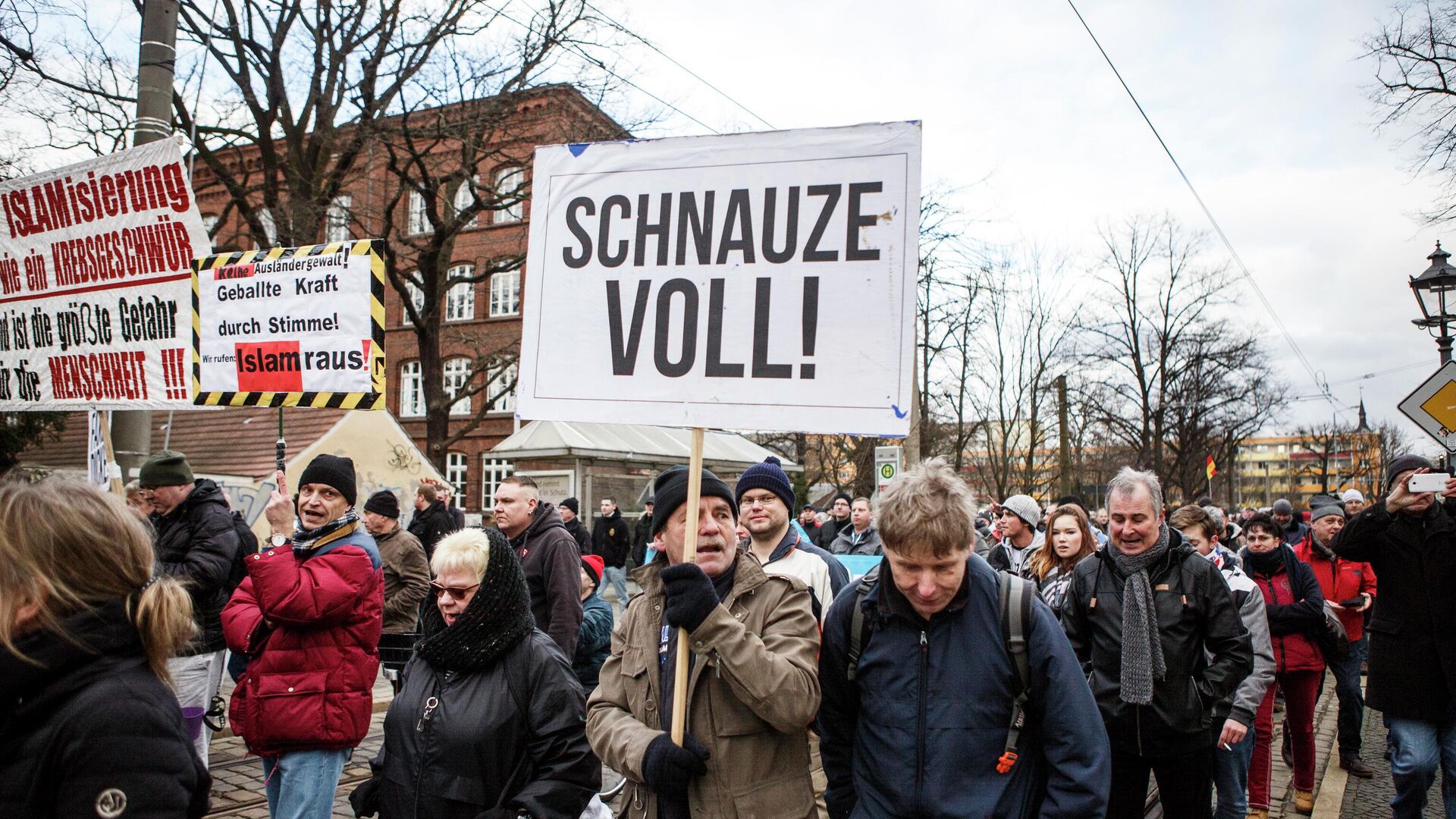 Участник с плакатом Я сыт по горло на акции протеста против большого числа беженцев, в основном мусульман, которые переехали в немецкий Котбус за последние годы - ИноСМИ, 1920, 19.11.2025