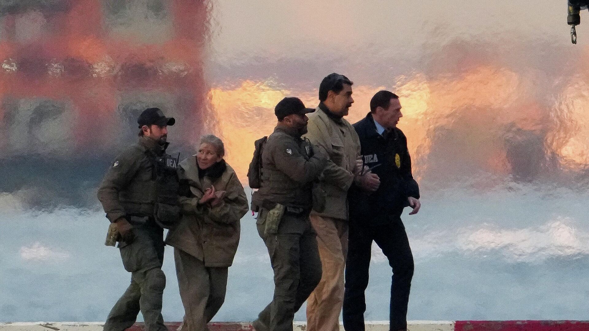 Сотрудники правоохранительных органов выводят захваченных в плен президента Венесуэлы Николаса Мадуро и его супругу Силию Флорес из вертолета - ИноСМИ, 1920, 05.01.2026