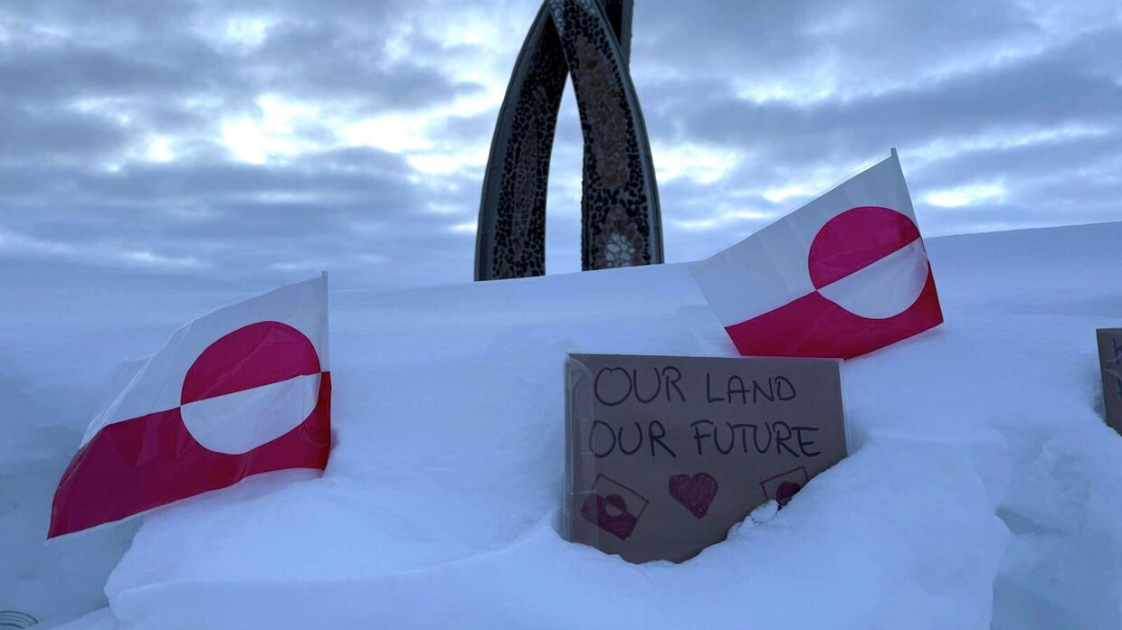 Флаги Гренландии и табличка с надписью Наша земля - наше будущее во время визита вице-президента США Джей Ди Вэнса в Нуук