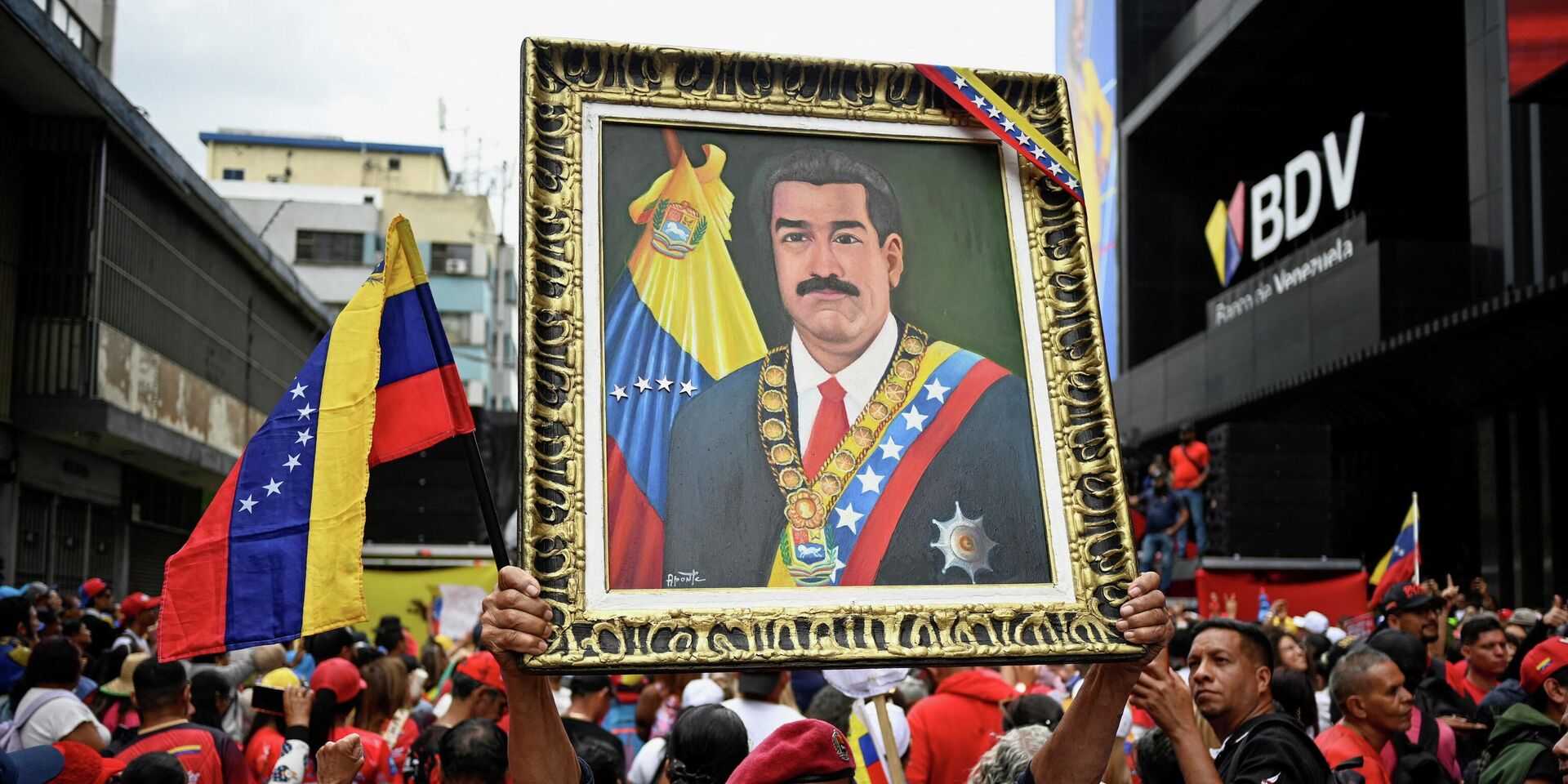 Демонстрант держит портрет президента Николаса Мадуро во время марша с требованием освободить Мадуро и его жену Силию Флорес, захваченных американскими войсками - ИноСМИ, 1920, 17.01.2026
