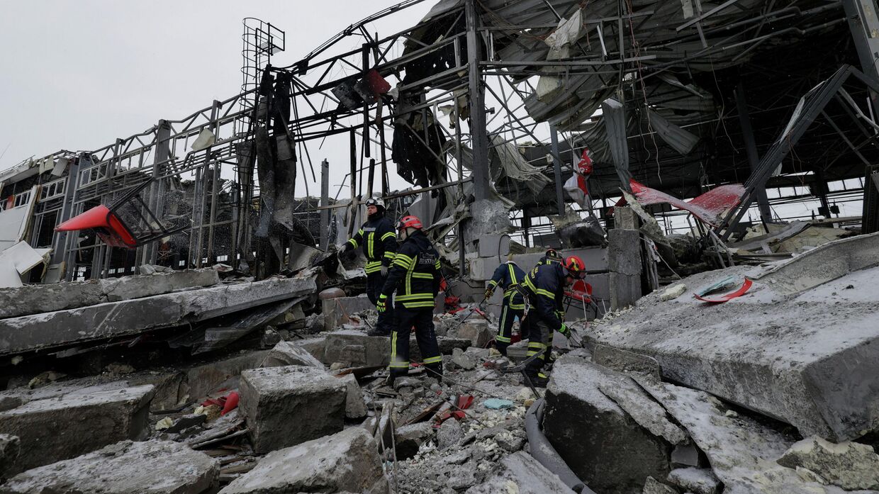 Спасатели работают на месте расположения логистического центра частной компании по доставке грузов, пострадавшего от российских ракетных ударов в Харькове