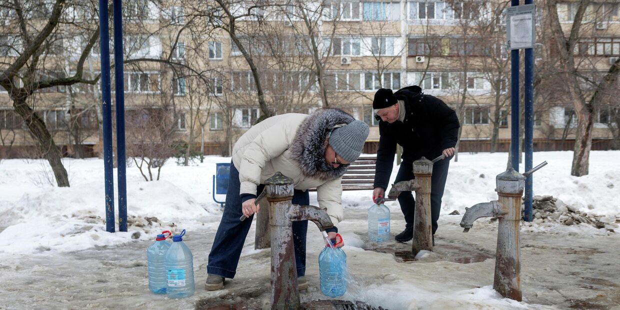 Люди набирают воду из общественной колонки в Киеве