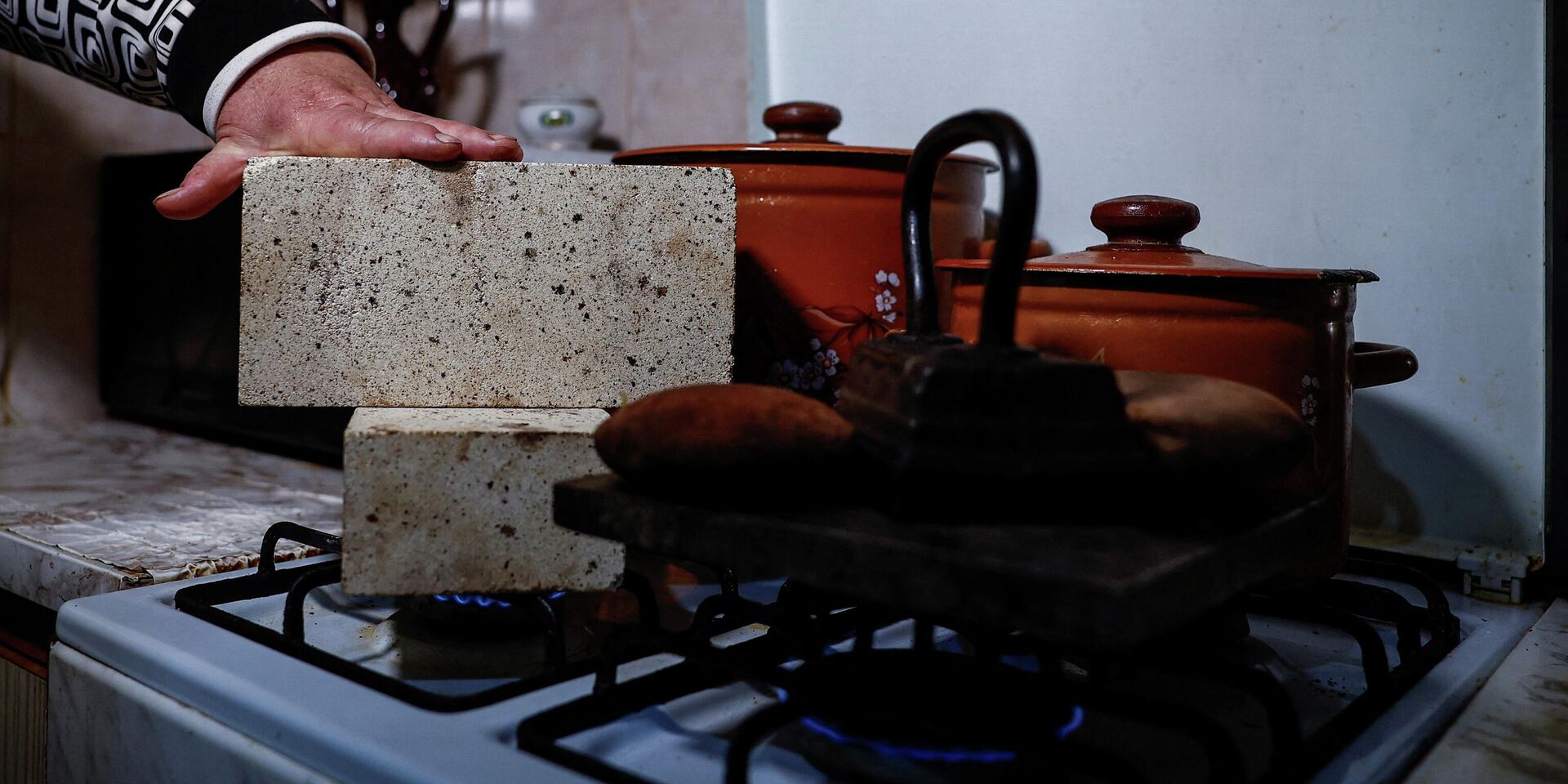 Киевлянка обогревает квартиру с помощью кирпичей, камней и чугунного утюга на газовой плите - ИноСМИ, 1920, 15.02.2026