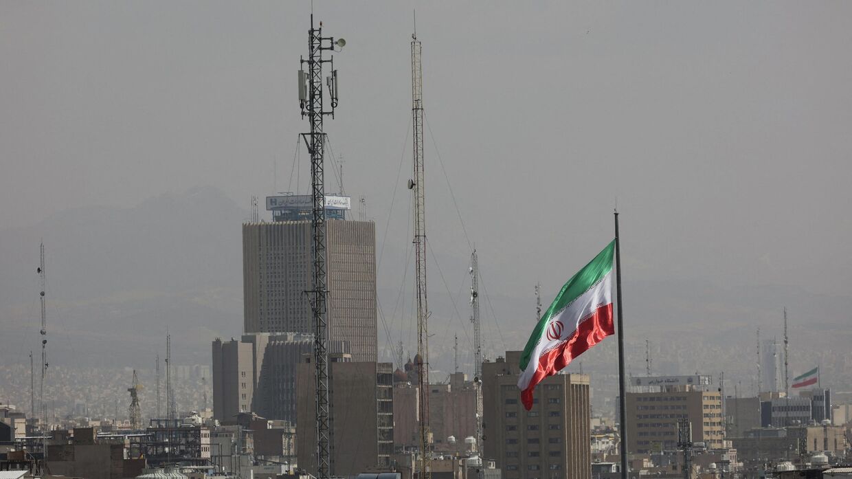 Иранский флаг развевается после ударов Израиля и США по Ирану. Тегеран, 28 февраля 2026 года