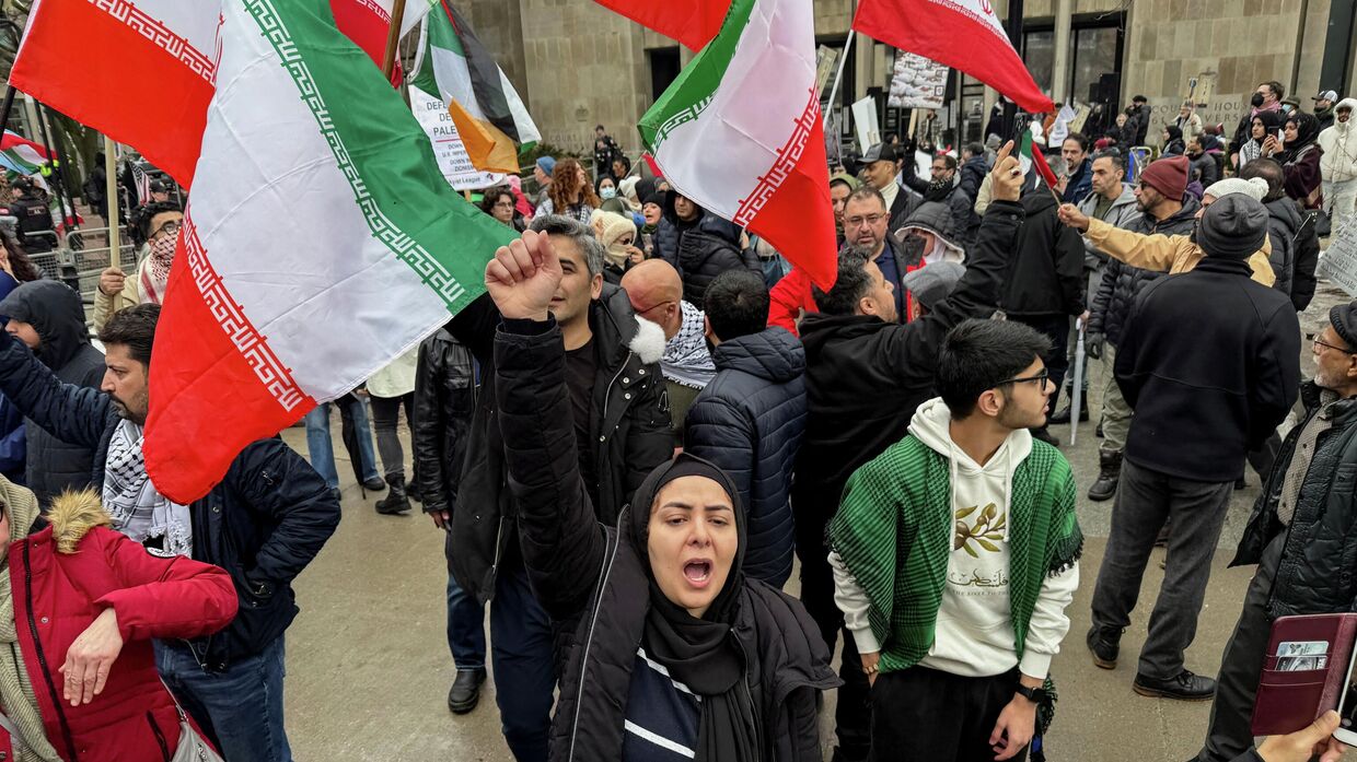 Протестующие рядом с митингом сторонников конфликта Израиля и США с Ираном в Торонто