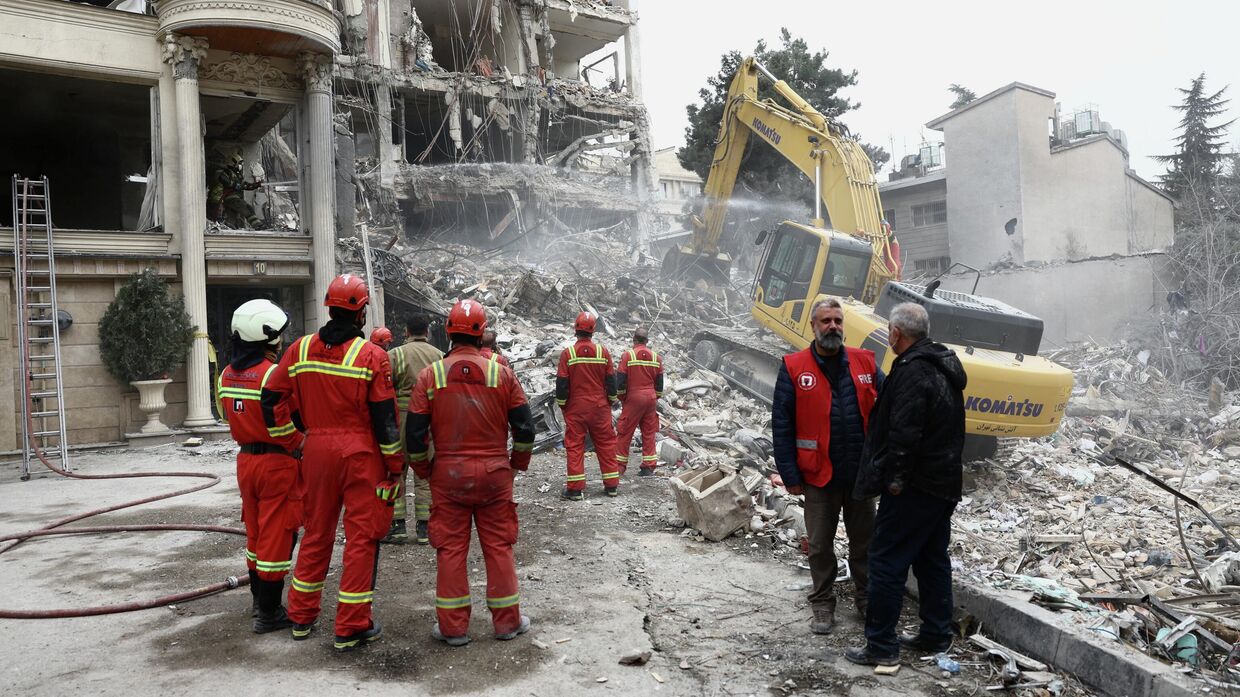 Сотрудники экстренных служб работают на месте удара по жилому зданию в Тегеране, Иран, 23 марта 2026 года