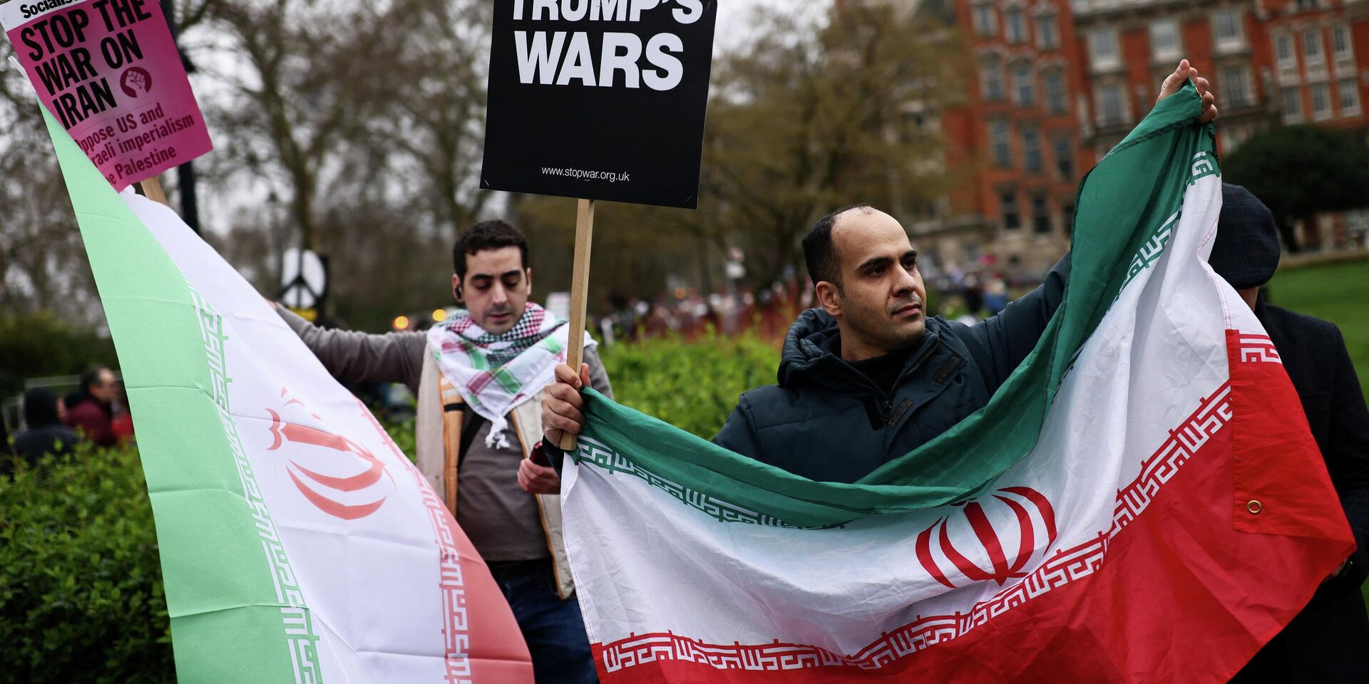 Демонстранты держат плакаты и иранские флаги, а антивоенные активисты собираются на марш, призывая к прекращению военных действий на фоне американо-израильского конфликта с Ираном - ИноСМИ, 1920, 06.04.2026