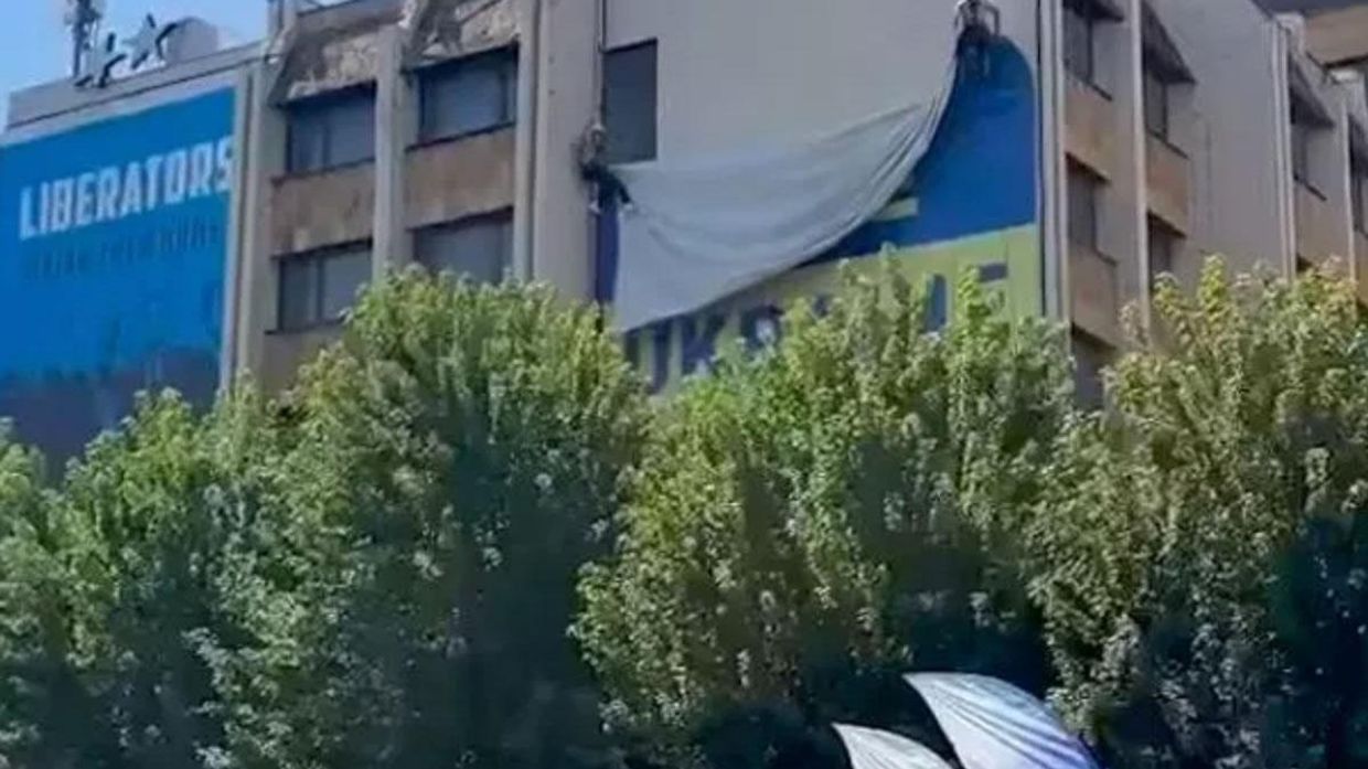Рабочие снимают флаг Украины со здания в Приштине