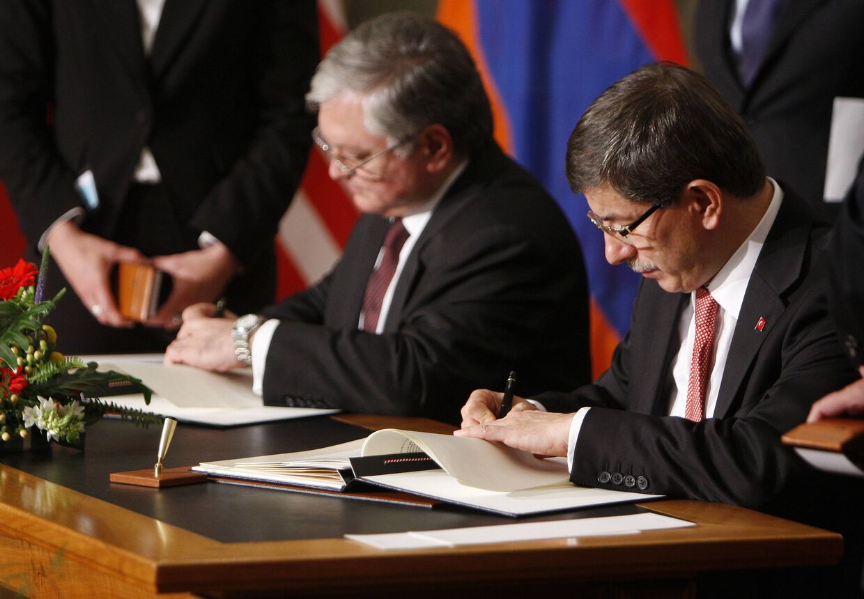 Эдуард Налбандян и Ахмет Давутоглу подписывают документы во время церемонии заключения мирового соглашения между Арменией и Турцией
