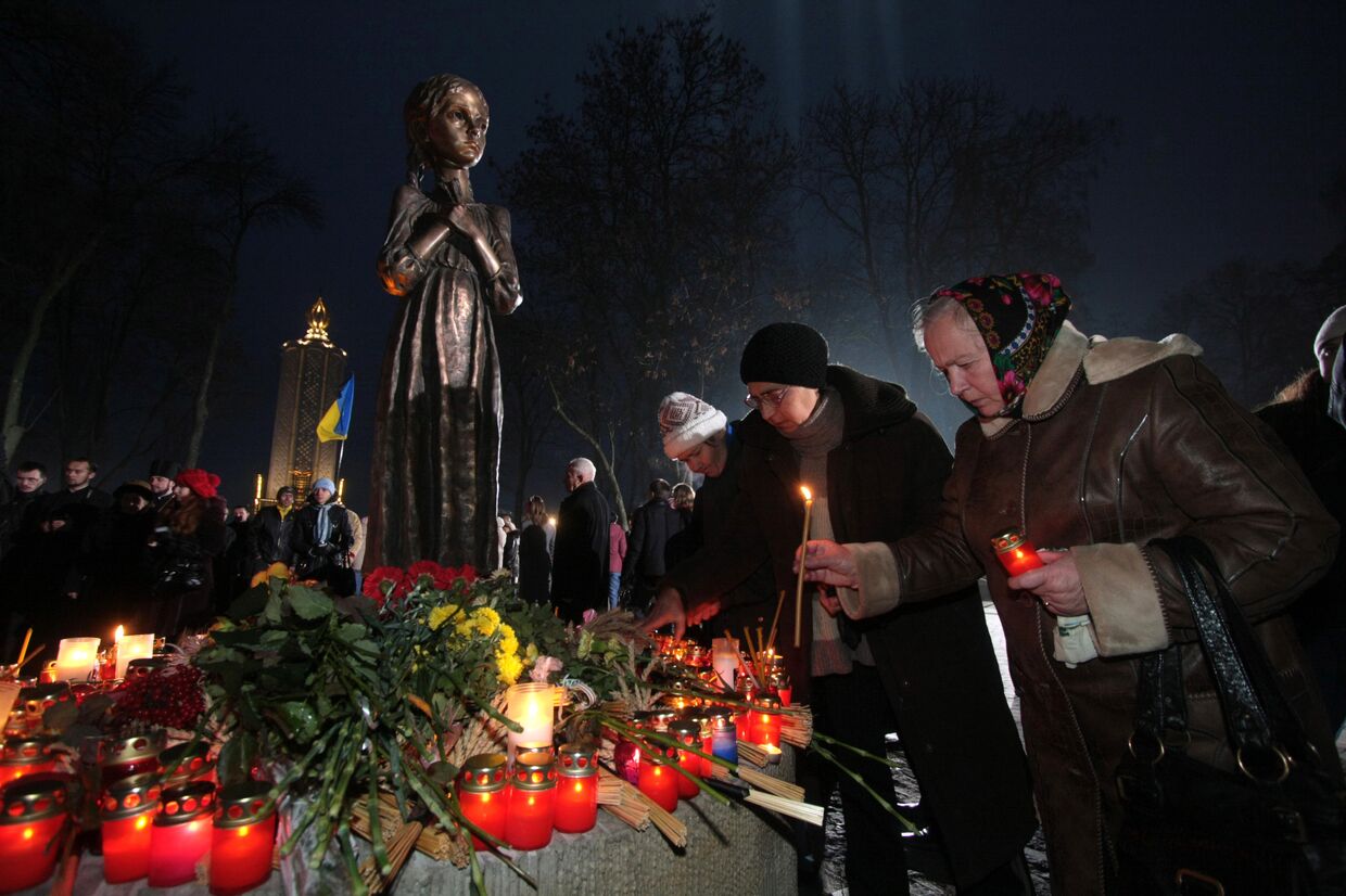 Участники всеукраинской акции Зажги свечу ставят символические лампады к мемориалу памяти жертв голодомора