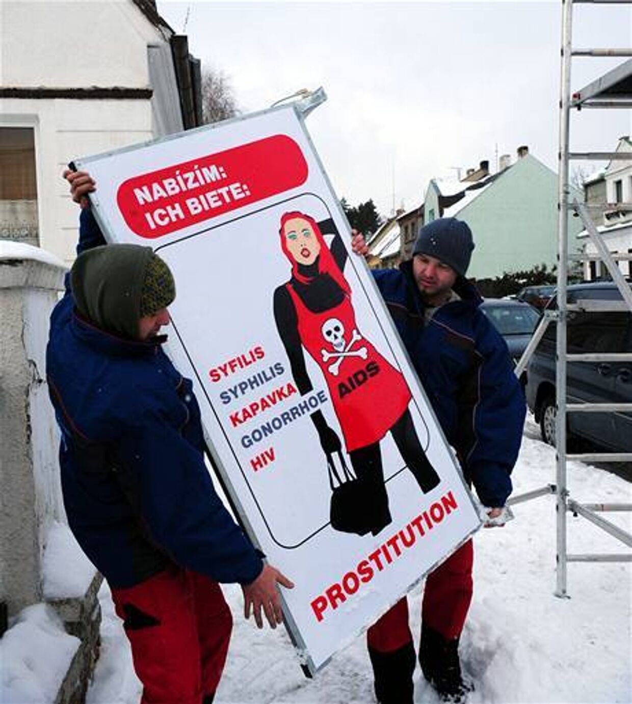 Рабочие готовятся повесить плакат в чешском городе Хомутов