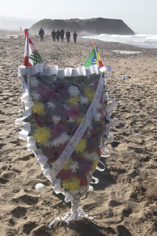 Родственники погибших оставляют на берегу цветы и свечи