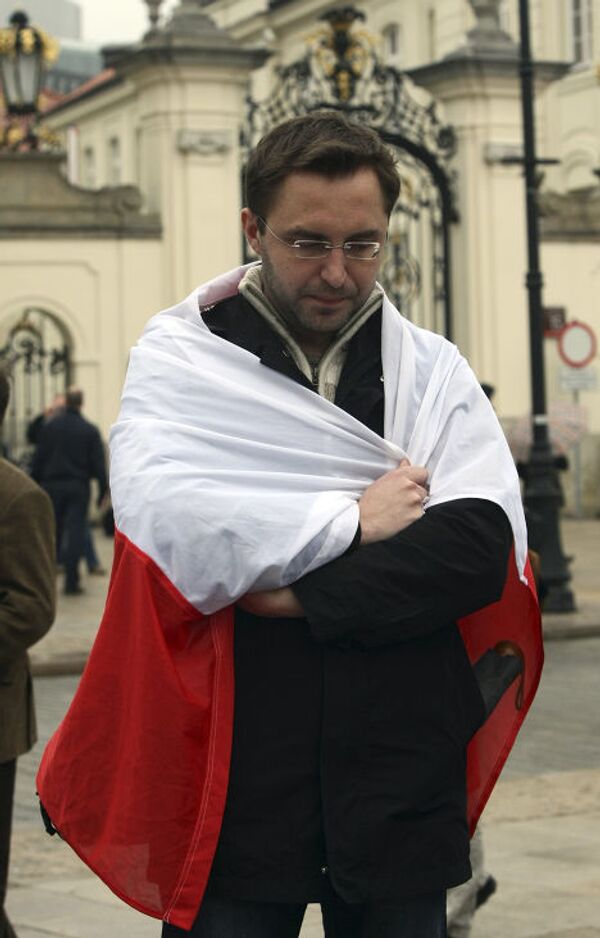Мужчина с национальным флагом Польши возле президентского дворца в Варшаве