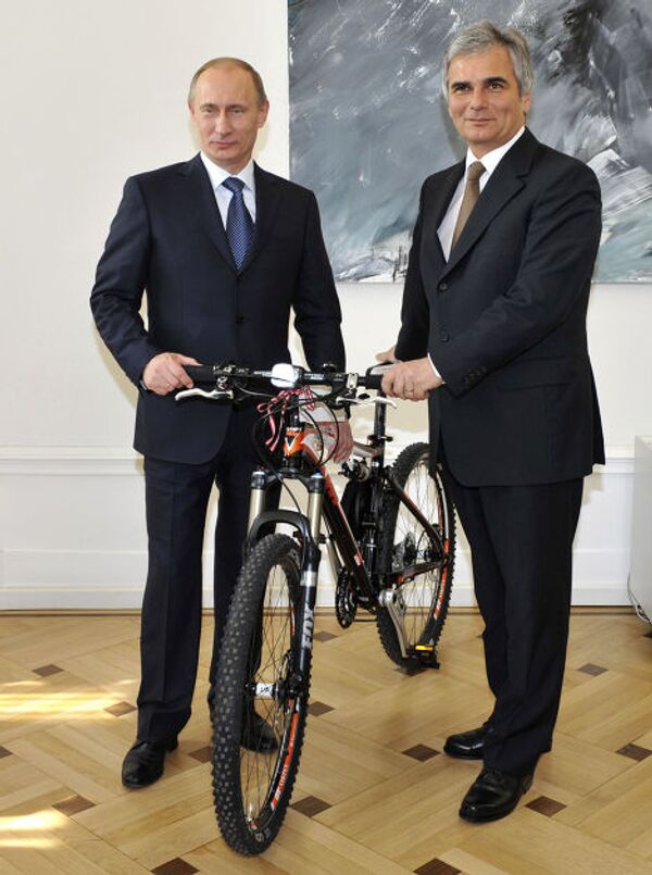 Федеральный канцлер Австрии Вернер Файман презентует Владимиру Путину велосипед