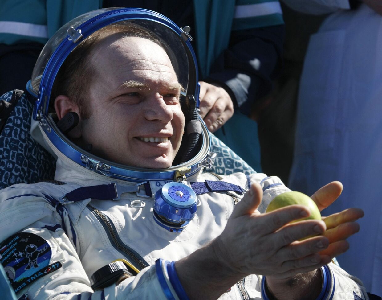 российский космонавт Олег Котов с яблоком  после приземления капсулы