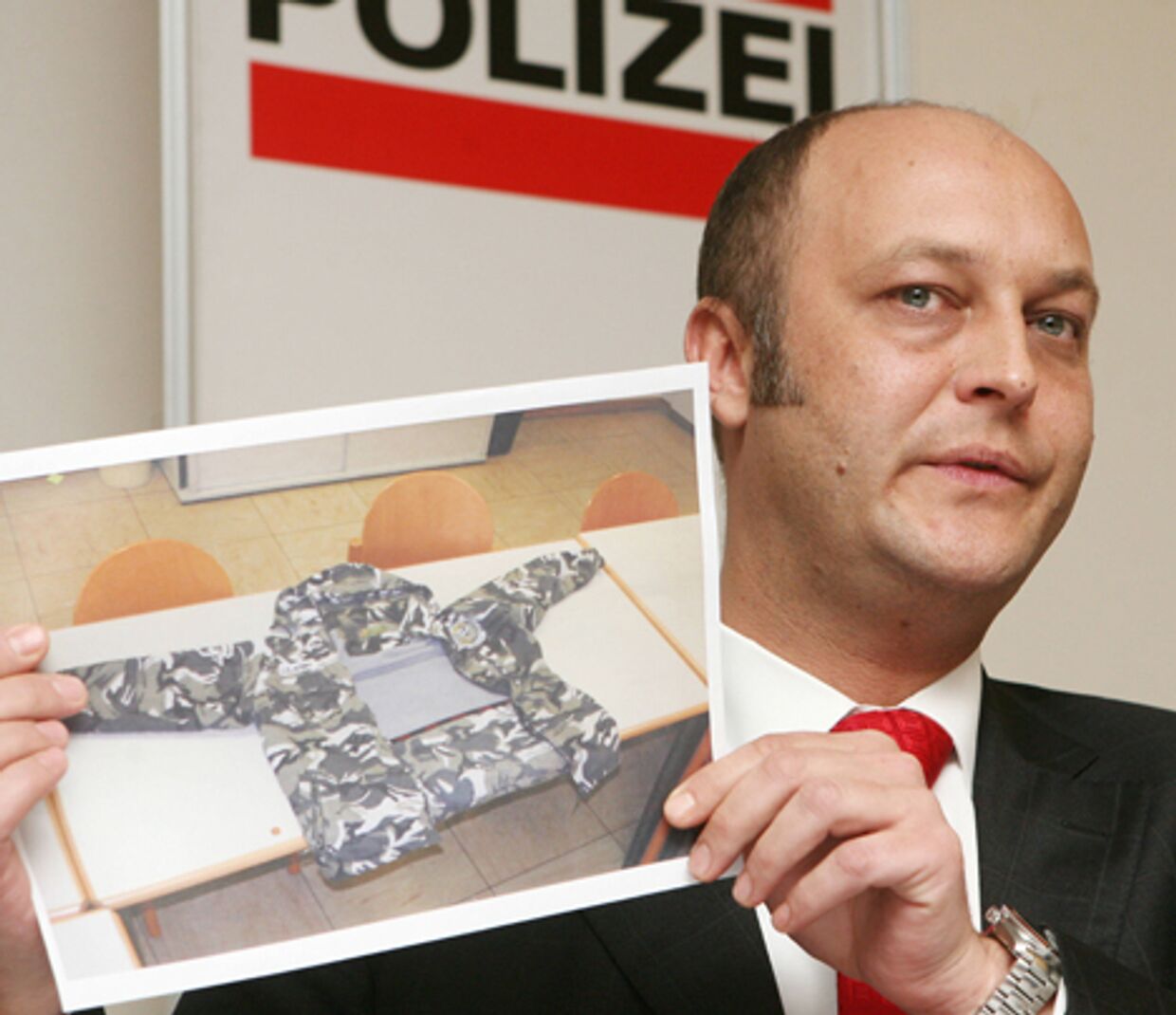 Австрийский государственный прокурор Герхард Ярош показывает фото из дела об убийстве умара исраилова