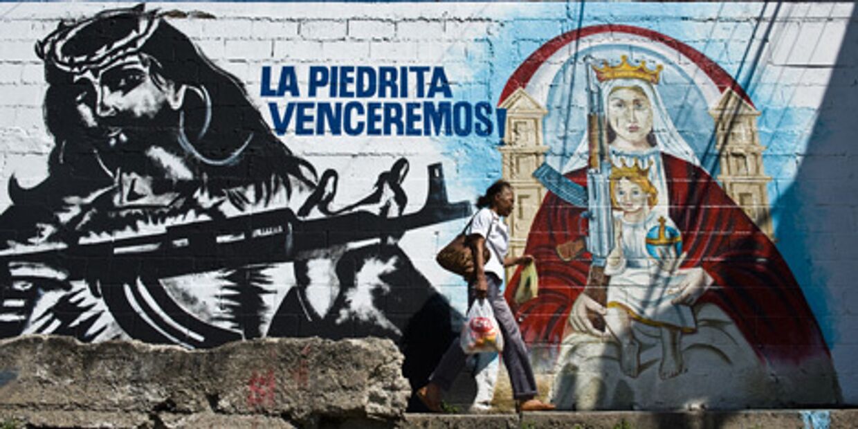Граффити Иисуса с автоматом калашникова на стене здания в каракасе, венесуэла