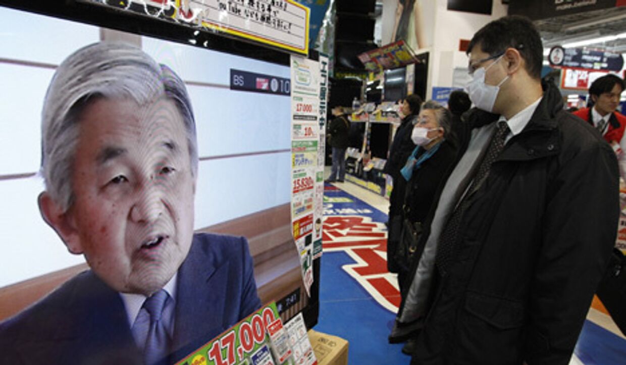 Жители Токио смотрят по телевизору выступление императора японии акихито