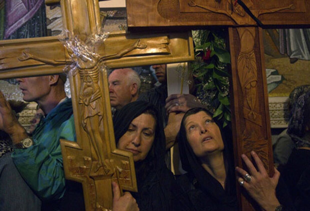 Православные христиане держат деревянные кресты в Иерусалимском храме