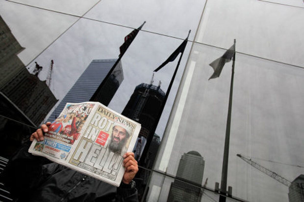 Мужчина читает газету с заголовком о ликвидации Усамы бен Ладена в центре Нью-Йорка