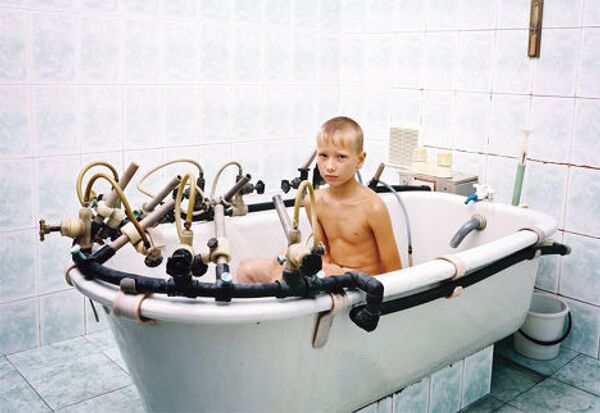 Юный Дима погружает травмированную ногу в ванну в спа «Мацеста»