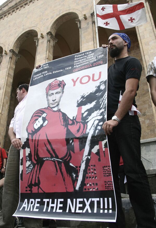 грузинские оппозиционеры держат плакат с изображением путина