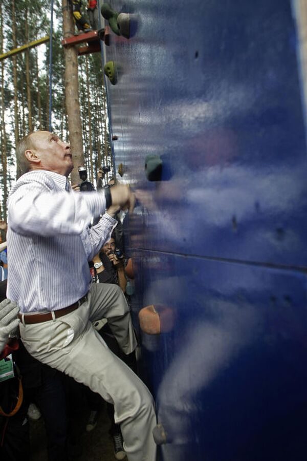 Премьер-министр России Владимир Путин взбирается на стену для скалолазания в ходе визита на Селигер