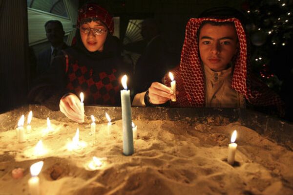 Иорданские христиане зажигают свечи после посещения рождественской мессы в Аммане
