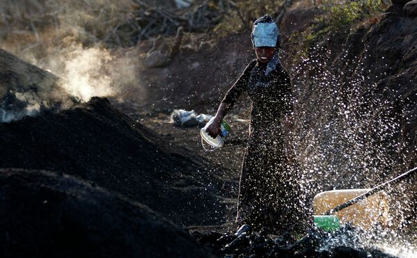 Женщина участвует в изготовке угля в городе Кызылджахамам, Турция