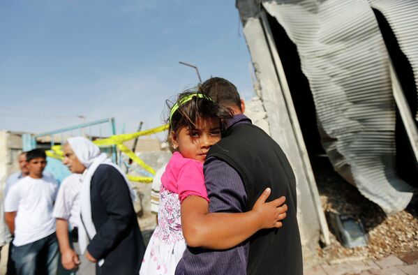 Мужчина держит на руках ребенка в приграничном уезде Акчакале на юго-востоке Турции