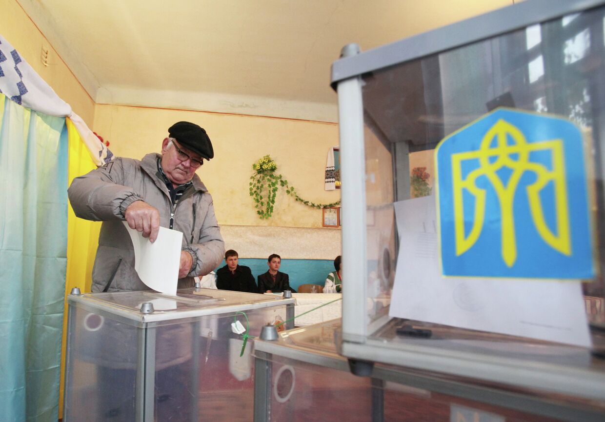 Мужчина голосует на выборах в Верховную Раду Украины