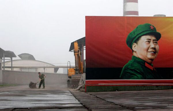 Рабочий проводит уборку возле плаката Мао Цзэдуна на тепловой электростанции Nanjie Cun Group