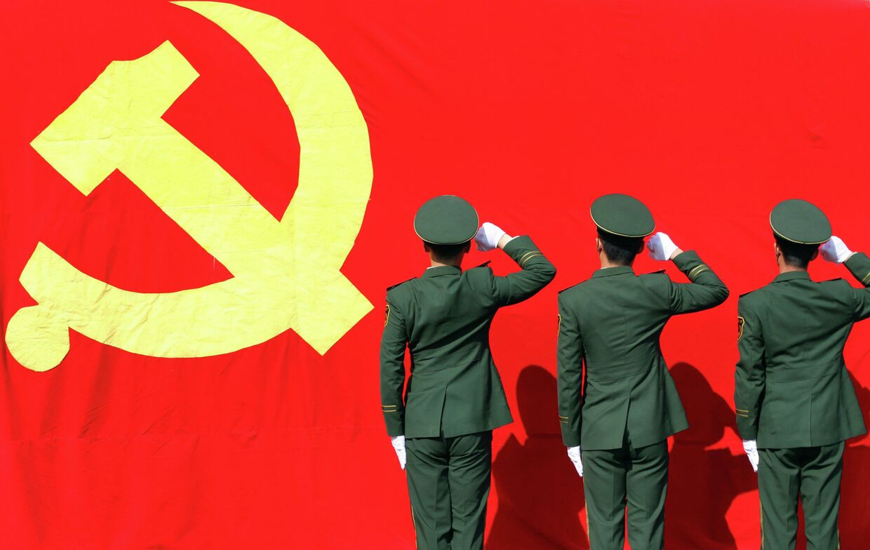 Военизированные полицейские отдают честь флагу Коммунистической партии Китая